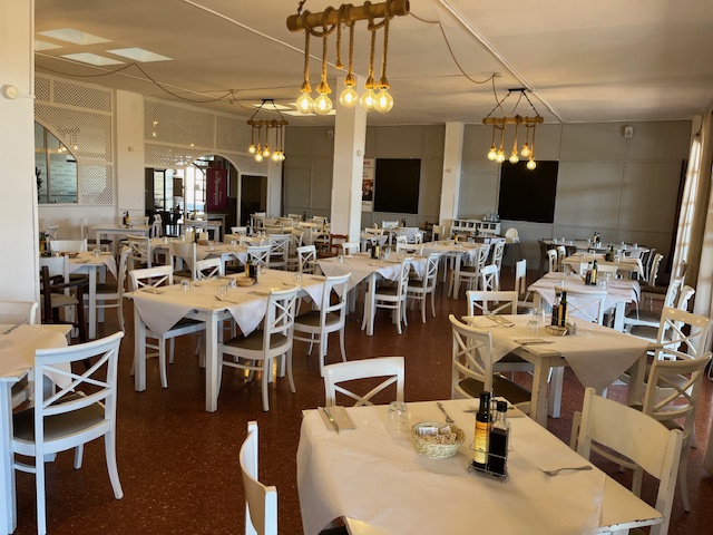 Bright and spacious restaurant with neatly set tables and warm lighting.